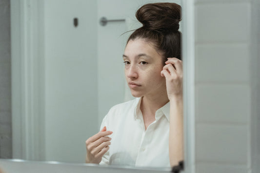 woman gazing into her mirror for confidence; lighted mirror for self-reflection.